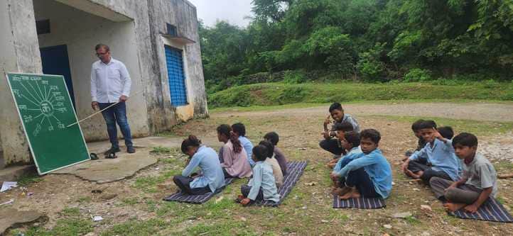 राजकीय विद्यालय भौमपाड़ा में मैदान में बैठकर पढ़ाई करते विद्यार्थी।