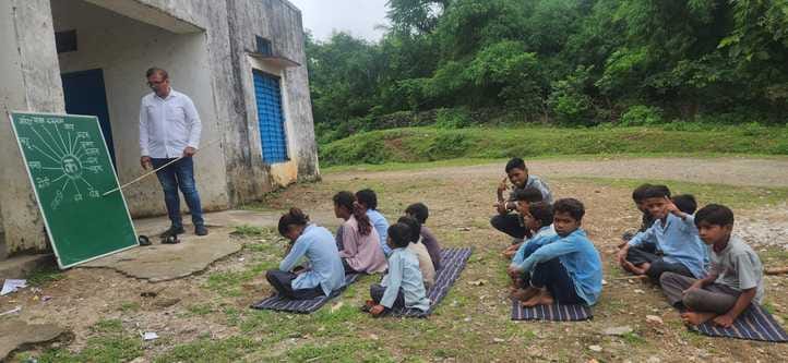 राजकीय विद्यालय भौमपाड़ा में मैदान में बैठकर पढ़ाई करते विद्यार्थी।