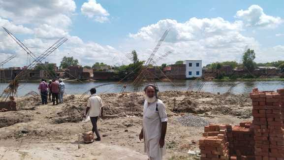 People are encroaching on the pond along the highway and constructing permanent buildings