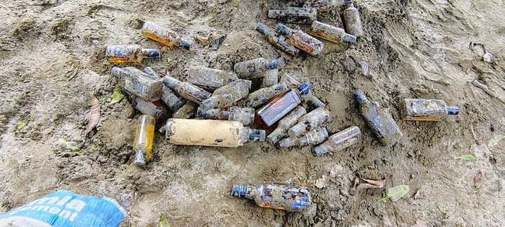 गम्हरिया थाना परिसर में खुदाई के दौरान मिट्टी के अंदर से मिली शराब की बोतलें
