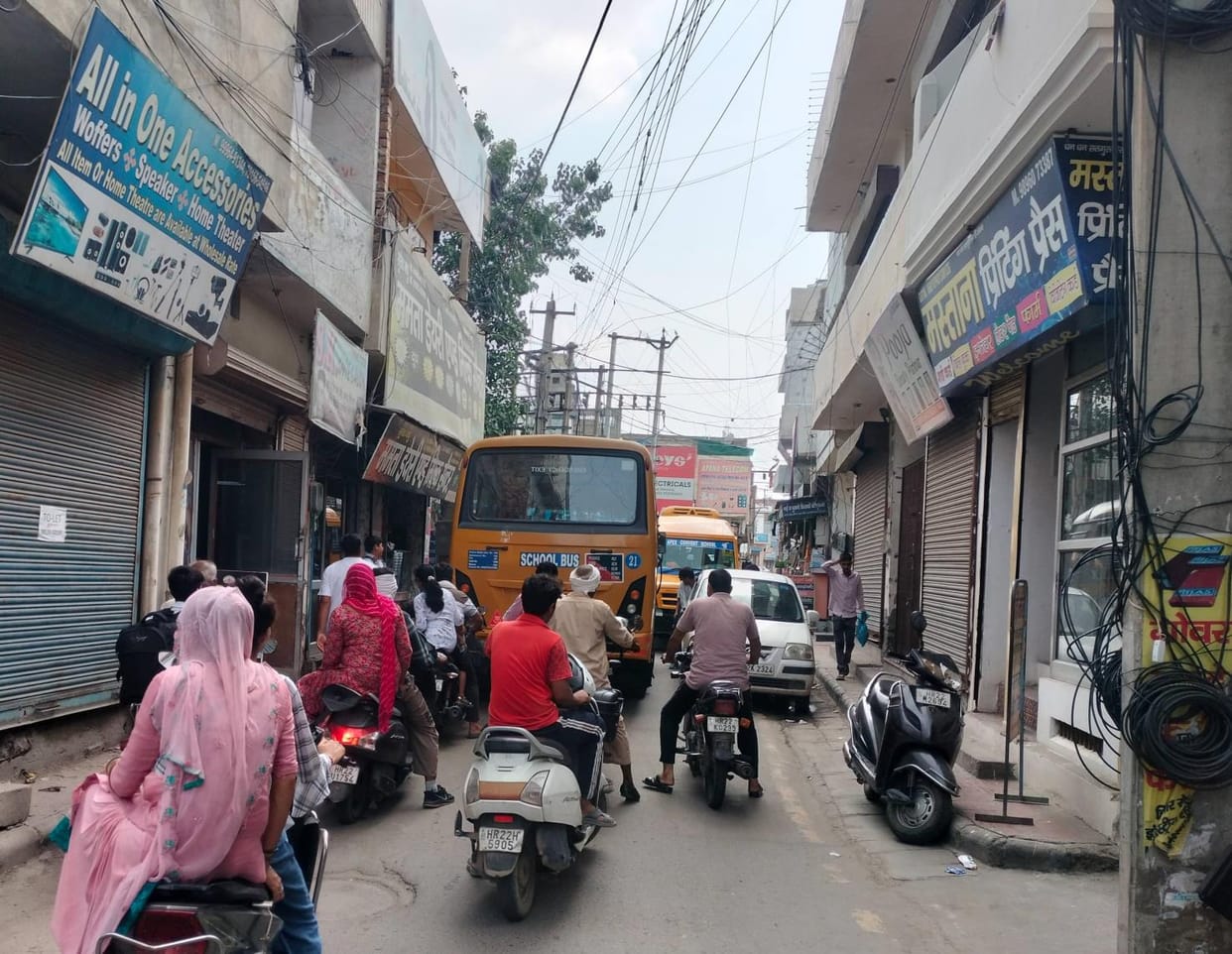 Big school buses are entering narrow streets, causing traffic jams