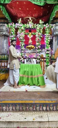 Sitting on a swing made of flowers and leaves, the King of Kings gave darshan