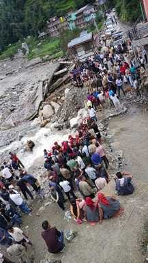 Rushad villagers sit on the road to divert the drain from the old bridge in Pandavashila