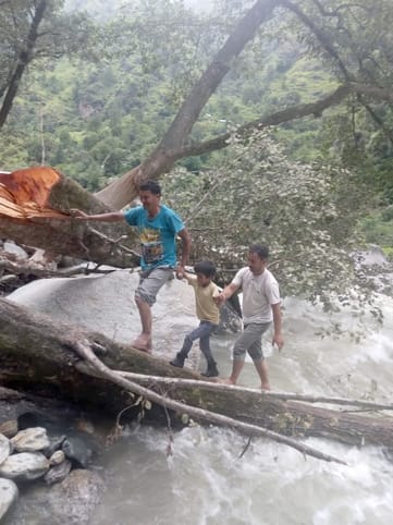 The culvert was washed away and people were crossing the drain by walking on the trunk of a broken tree