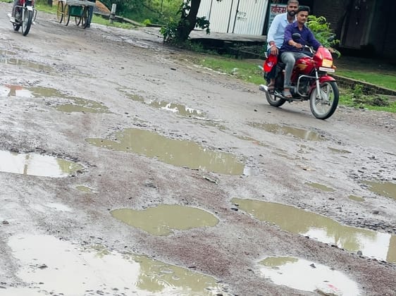 Rain washed away gravel and dust, potholes on the road