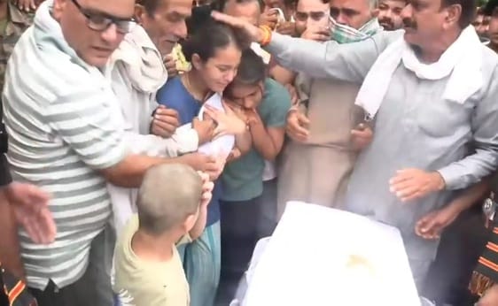 Saluting the martyr amidst tears, daughters put their father's symbol on their chest