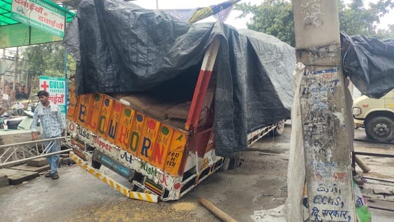 A truck loaded with wheat got stuck after a drain slab broke near the post office in Ward-24