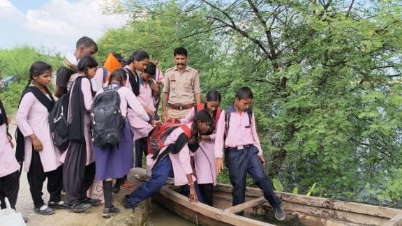 School children of flood affected village travel under police protection