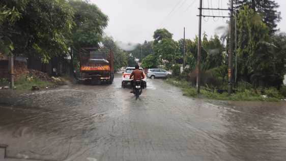 बारिश के दौरान गुजरते वाहन।