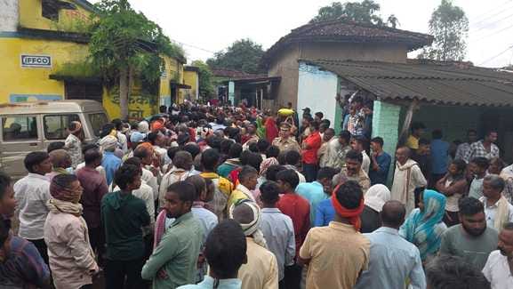 Farmers stood in the rain with umbrellas for fertilizers