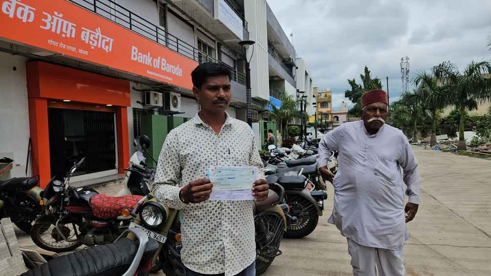 क्लेम राशि की रसीद दिखाते किसान।
