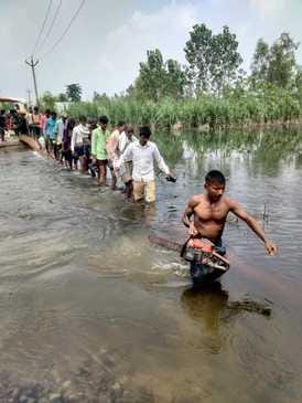 People are crossing the drain with the help of sticks risking their lives