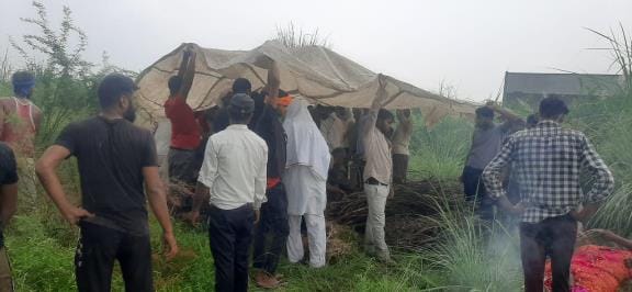 The old lady was cremated using a tarpaulin in the rain