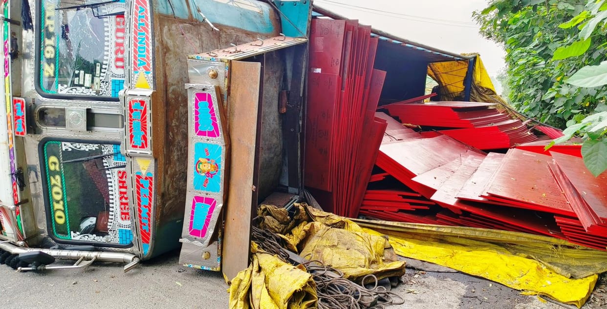 A truck loaded with plywood overturned after hitting a divider