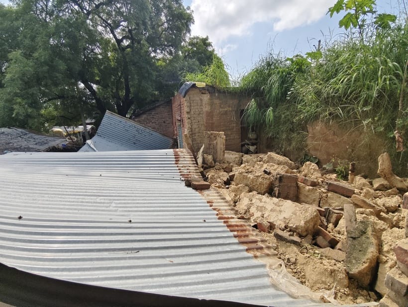 Rain-damaged houses, families living under open sky