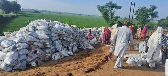Workers working to strengthen the ring dam on Rangoi drain