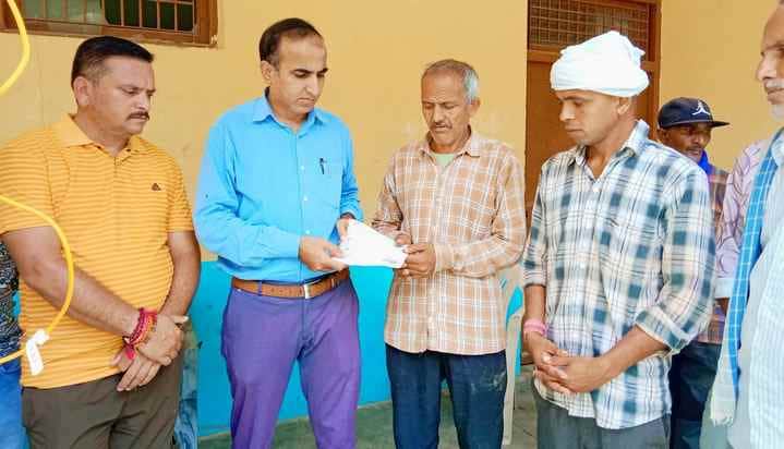 फोटो 01 कच्चे मकान में दबकर मृत्यु का शिकार हुए परिवार को राहत राशि का चैक सौंपते हुए तहसीलदार 