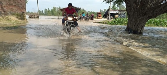 Road cut off due to flood in Bahgul river... People are crossing the road risking their lives