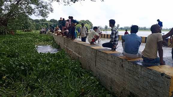 Water drainage stopped due to water hyacinth stuck on the Mala river bridge, traffic halted