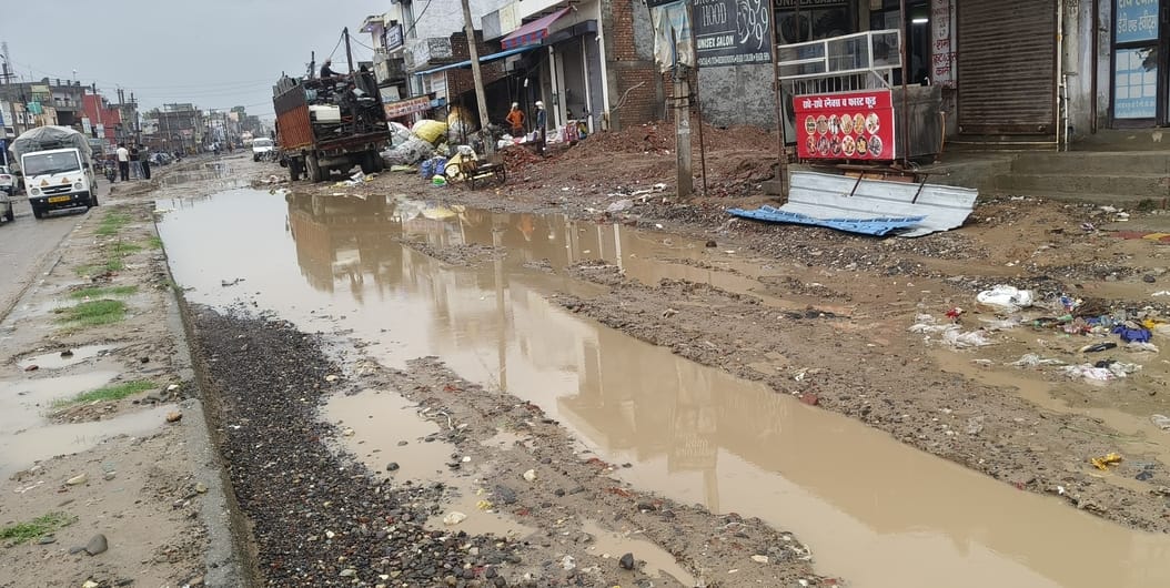 Pedestrians wait for the road to be built