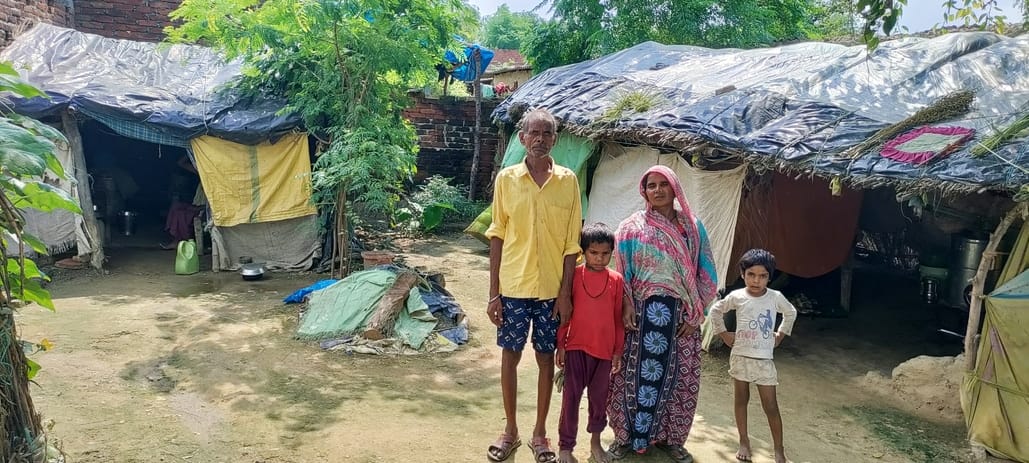 Homeless families living under tarpaulin in the rain, no housing provided