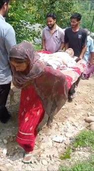 The road is in bad condition, forcing patients to be carried to the hospital on cots.
