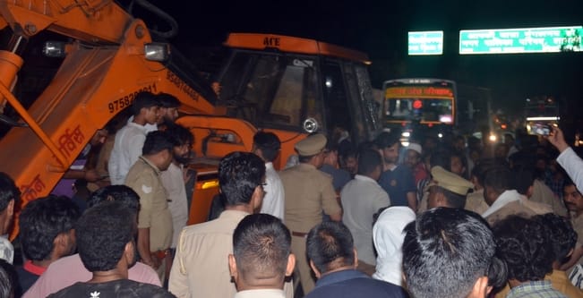 A worker on a bicycle is crushed to death by a crane, sparking a commotion among villagers.