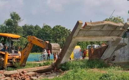 Bulldozer runs on the boundary wall and room built in the barn