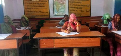 Elderly grandparents arrived for their exams, holding pens and sticks.