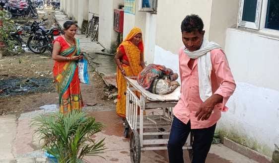 Staff absent, attendants pull patient stretchers themselves