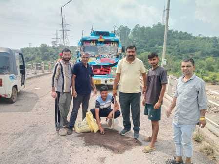 E-rickshaw drivers filled the deep potholes on the road.