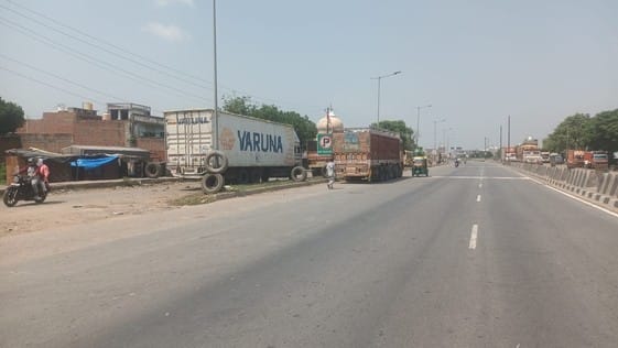 Vehicles are being repaired on the service lane, while the main lane has become a parking lot.