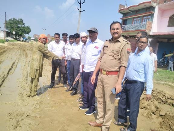 Hindu leader lying in the mud as construction of the bypass begins.