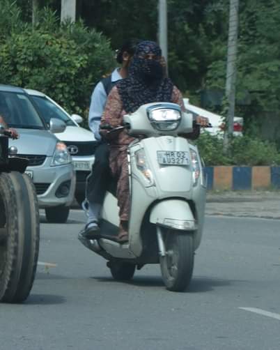 मुंह ढक कर गुजरती एक्टिवा सवार युवती। संवाद