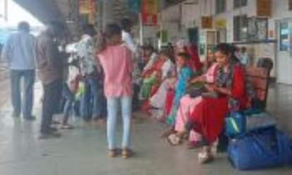 शहर के रेलवे स्टेशन पर ट्रेन का इंतजार करते यात्री।