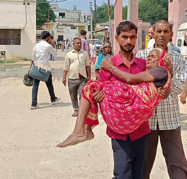 Unable to find a stretcher, the son carried his elderly mother in his arms
