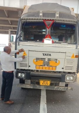Traffic police put reflector tape on commercial vehicles
