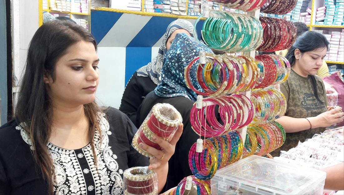 Women's hands decorated with mehndi, crowds gathered in the markets
