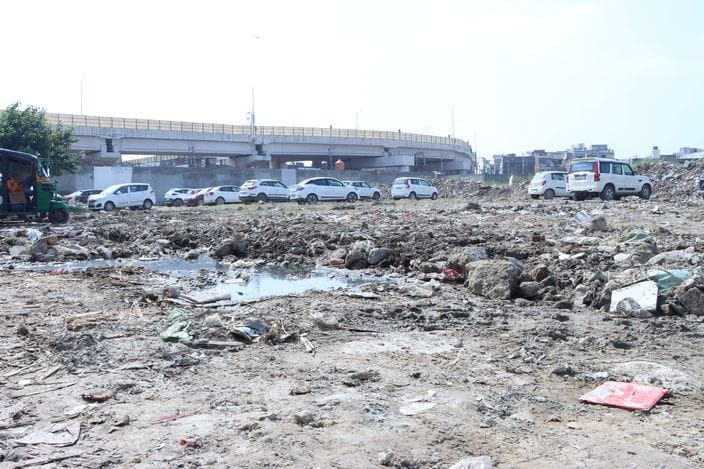 There is no space in the permanent parking lot, bricks, stones and garbage are spread in the temporary parking lot.