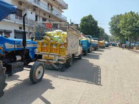 A queue of tractor-trolleys formed in the market, causing traffic jam.