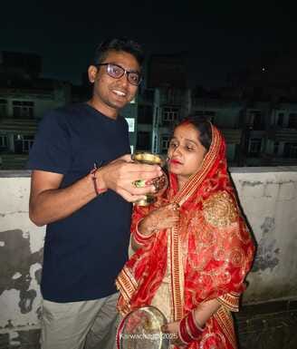 By offering prayers to the moon and wishing for a long life for the husband