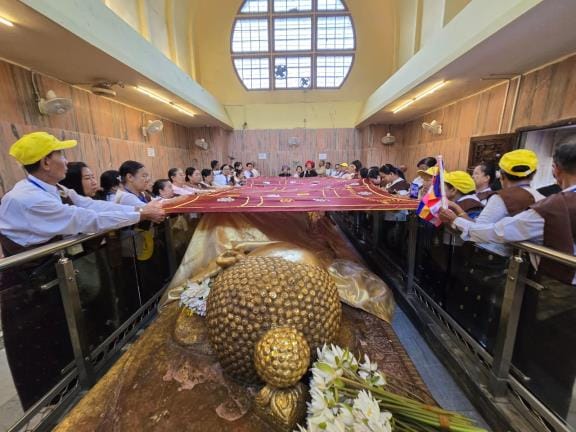 Myanmar tourists bow their heads before the Buddha statue