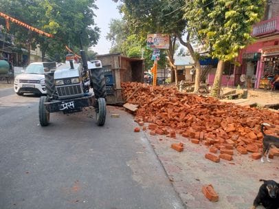 Tractor trolley loaded with bricks overturned