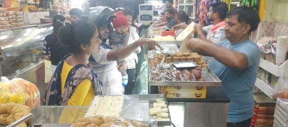 Shopkeepers weighing sweets with boxes