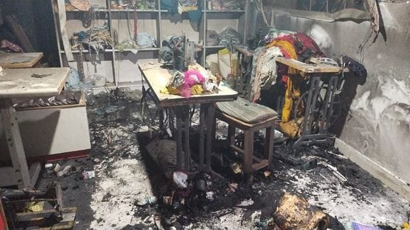 A short circuit caused a fire in a shop, burning clothes and machinery.