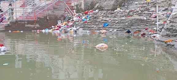 Two teams are cleaning, yet two feet of silt have accumulated on the ghats.