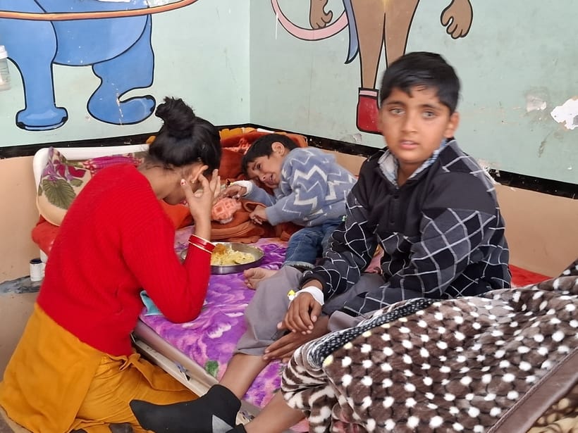 Two children are being treated on one bed in Kullu hospital.