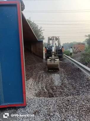 फोटो-11-डंपर पलटने कानपुर-लखनऊ हाईवे पर बिखरी गिट्टी हटाती जेसीबी। संवाद