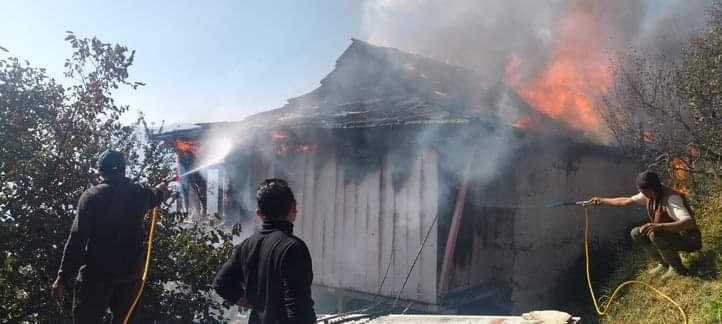 चौपाल की ग्राम पंचायत गोरली मड़ावग में घर में लगी आग को बुझाने का प्रयास करते लोग। संवाद