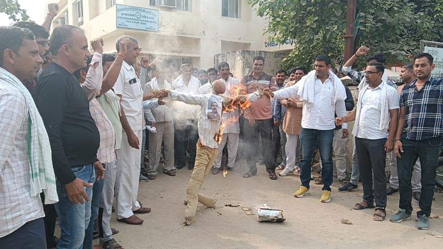 कार्यालय के गेट पर शहरी एसडीओ का प्रतीकात्मक पुतला जलाते कर्मचारी। संवाद